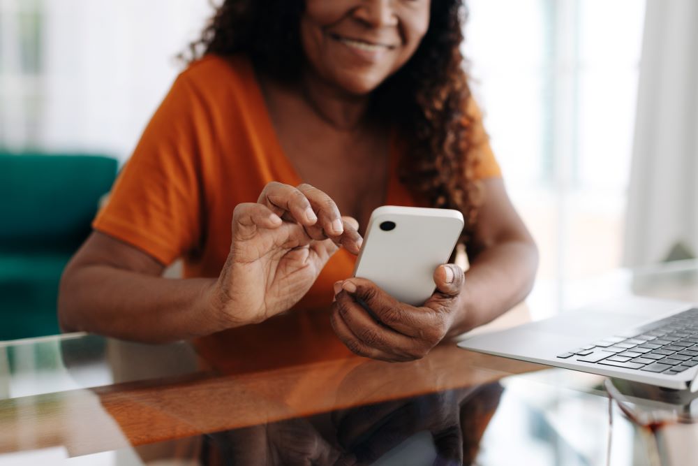 Cheerful senior woman looking at her smartphone